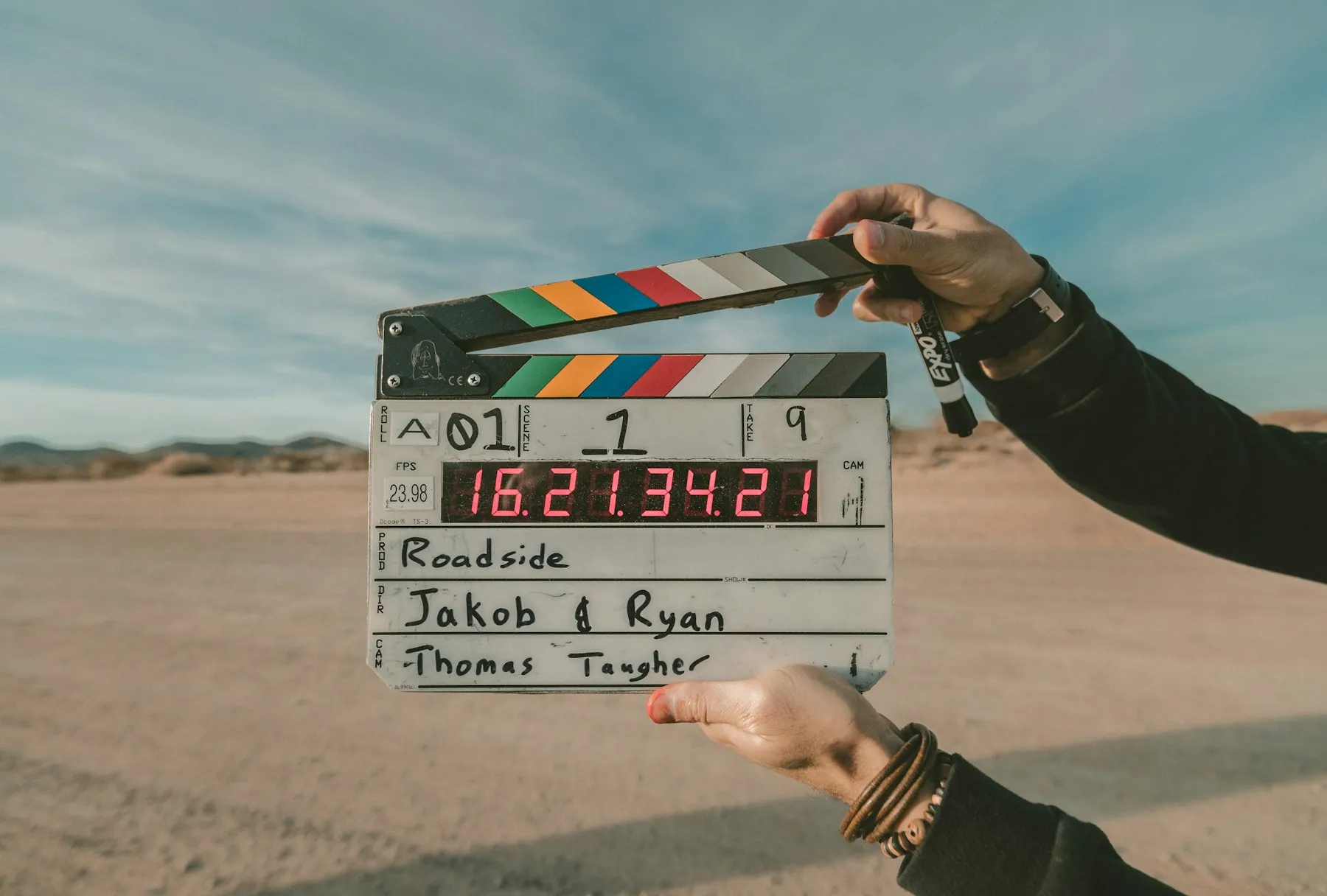A film clapperboard held up in warm golden light on set